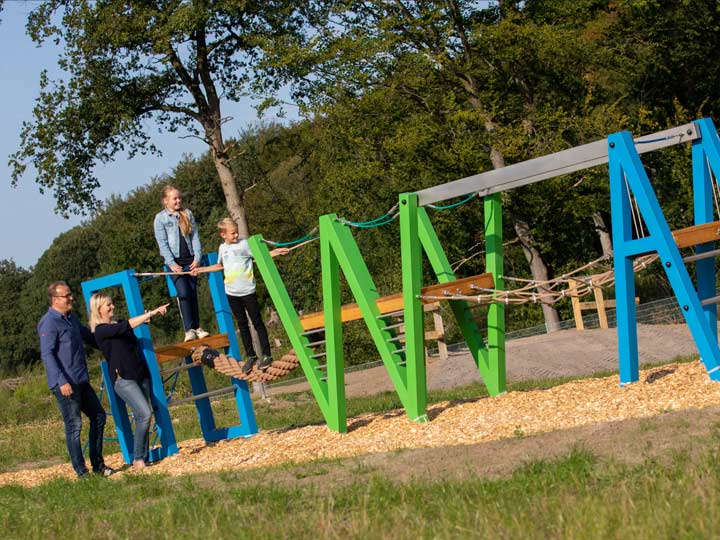 Kinder und Eltern spielen auf dem AWG-Klettergerüst im Eingangsbereich