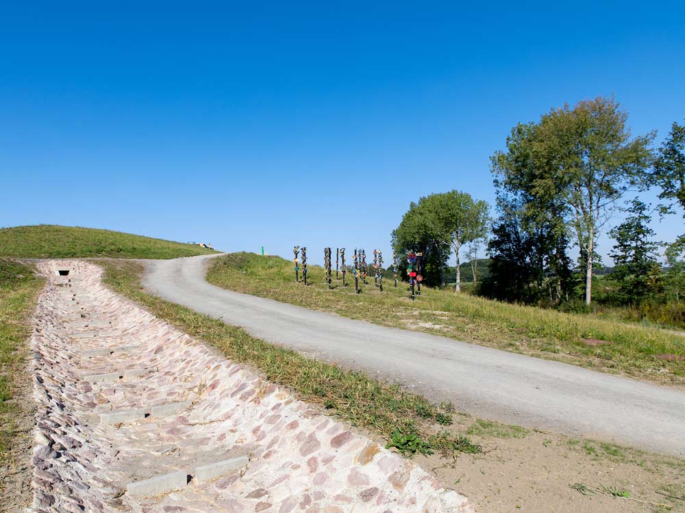 Der Weg vom Eingang zum Aussichtsplateau. Links der Regenwasserablauf, rechts Stelen des Gymnasiums Syke